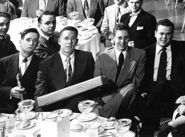 Theta Chi Founders Day Celebration Spring 1950 -  Bill with the box is the fraternity president. We will be Japan serving in the Army (Sasabo) concentrating on not crossing over to Korea. Our trip across the US waits for the summer. Nancy an I plan to marry in the coming January. If you couldn't tell, that's me in the light tan double breasted coat. I would graduate, work briefly for Sear's and be drafted into the Army a year after that. (Marriage tat is.) I would be in the Army nearly three years. I did not know then, or event suspect, what was just ahead, coming down the road. More white swans than black, but they are hard to identify when they first fly in.