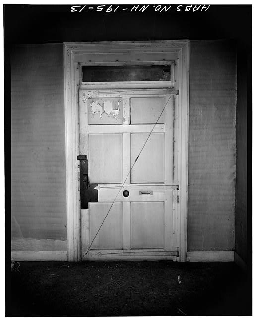 Main entrance door looking south. Note wide size with transom light and hand-wrought heart-shaped hinges